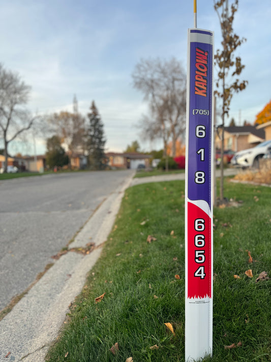 Blue and red lawn peg on a patch of grass. Peg says Kaplow! 706-618-6654.